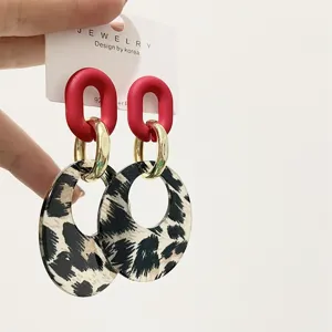Acrylic leopard print circle earrings with red upper loops and gold connectors for women.