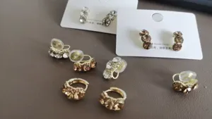 Detailansicht von Strass-Clip-Ohrringen und Ohrsteckern auf Präsentationskarten.