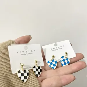 Close-up detail shot of cute black and white check heart earrings with s925 silver posts.