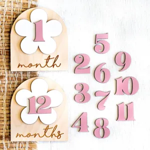 Wooden baby milestone cards with pink numbers and floral arch designs for photography props.