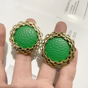 Retro green leather round earrings with antique gold chain border, stylish fashion jewelry.