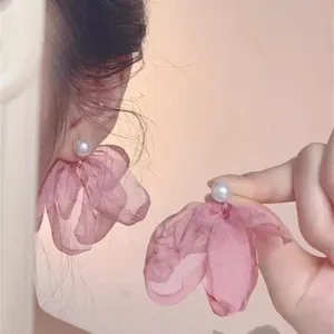Close-up detail of fairy-style pink chiffon flower and pearl stud earrings for women.