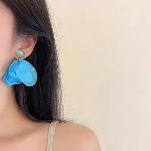Close-up detail of stunning blue fabric petal earrings, perfect for beach resort vacations.