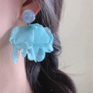 Detail close-up of blue flower organza earrings, showcasing delicate fabric petal texture.