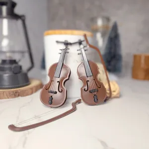 Close-up detail shot of miniature toy violins with bows, perfect dollhouse scene prop.