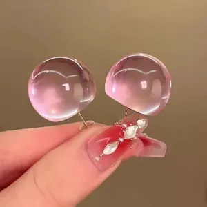 Close-up of trendy candy pink resin dome earrings, featuring a translucent bubble design style.