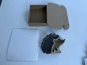 Detailed view of the wooden hedgehog piggy bank with its packaging box and bubble bag.