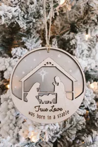 Houten acryl kerstboom hangend ornament met prachtig lasergesneden kerststalontwerp erin.