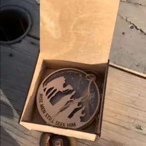 Gedetailleerd uitzicht op de houten acryl kersthangdecoratie in geschenkdoos.