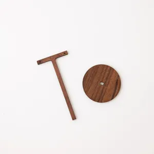 Dettaglio del supporto per orecchini in legno, supporto a T marrone vintage con base circolare.