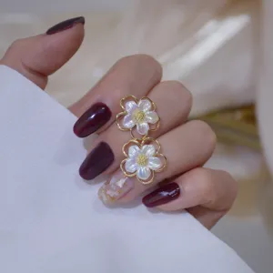 Detailed shot of exquisite double flower ring with mother of pearl and gold border on hand.