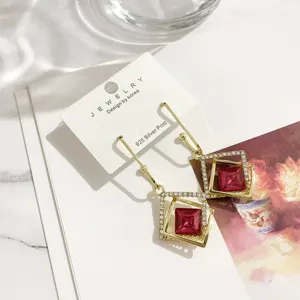 Exquisite geometrische Kristall-Ohrringe mit rosa Stein und elegantem Gold-Finish Detail.