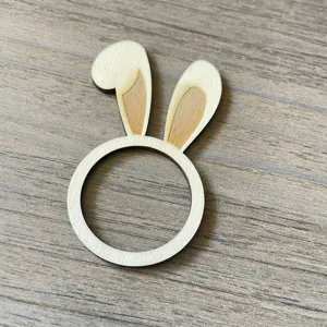 Close up view of cute wooden bunny ear napkin ring detail on textured tabletop display.