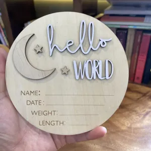 Wooden newborn baby announcement plaque detail showing moon, stars, and engraved milestone text fields.