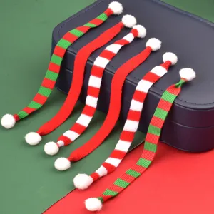 Toma detallada de mini bufandas de punto de Navidad con pompones, ideales para decoración.