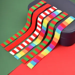 Detalle de mini bufanda tejida a rayas decorativa para botella de muñeca de Navidad colorida.
