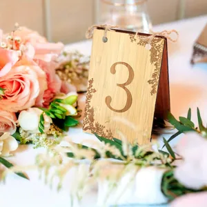 Wooden wedding table number sign with engraved number 3 and floral vine decor for party.