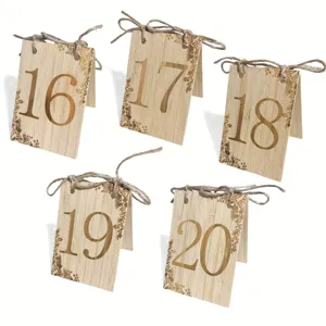 Wooden table number cards with twine bow and floral engraving for wedding party decor.