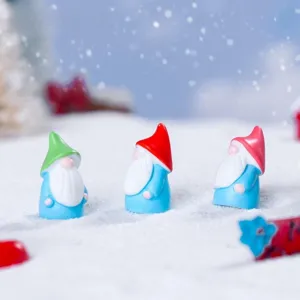 Primer plano macro de mini figuras de enanos de resina en la nieve para paisaje de suculentas.