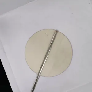Close-up detail view of a blank round wooden slice shown with a tape measure for precise sizing.