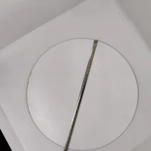 Detail shot of white round wooden slice being measured with a tape, ideal for DIY crafts.
