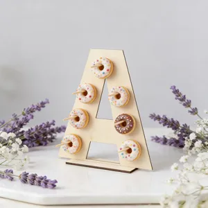 Wooden arch dessert display stand detail, showing miniature pastry props in wedding party setup.