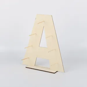 Wooden dessert display stand detail, letter shaped donut holder with pegs for party decor.