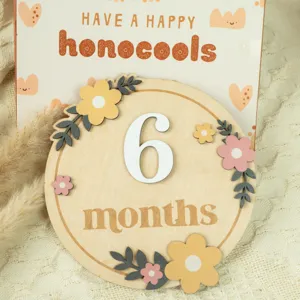 Wooden baby milestone card detail with 6 months text and floral decor for newborn photo props.