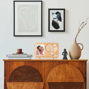 Wooden picture frame detail showing heart carved text and warm family photo display setup.