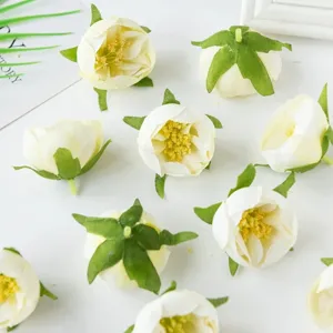 Nahaufnahme von künstlichen weißen Rosenblütenköpfen mit grünen Kelchblättern für DIY Basteln.