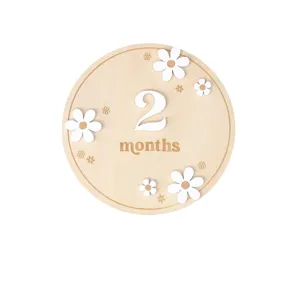 Wooden baby milestone card with cute white daisy flowers and engraved monthly numbers for photography.