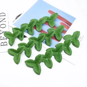 Dettaglio di foglie di fiori artificiali verdi triangolari, perfette per composizioni floreali.