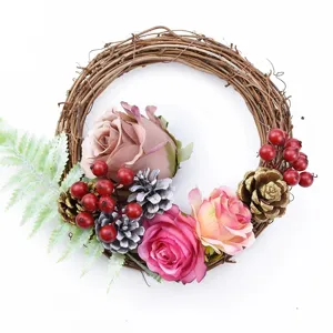Couronne de Noël en branches artisanale avec roses artificielles baies rouges et pommes de pin