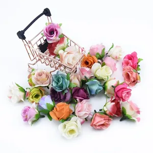 Vista dettagliata di teste di rose artificiali in seta colorata con mini carrello decorativo