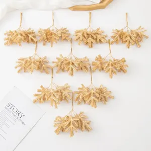 Gold artificial pine branches detail for Christmas tree decoration and DIY craft wreaths.