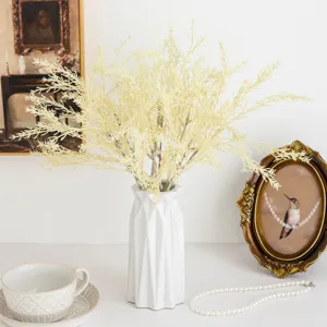Bouquet de faux rime dans un vase géométrique blanc, idéal pour la déco et le mariage.
