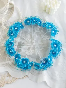 Detailaufnahme blauer Stoff-Kamelien-Haaraccessoires mit Perlen für brautliche DIY-Bastelarbeiten.