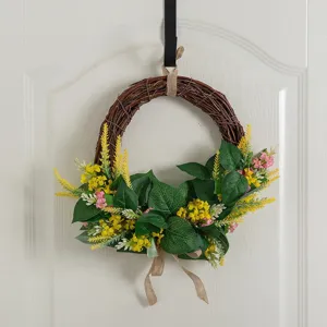 Artificial twig wreath with green leaves and yellow flowers, perfect for spring door decor.
