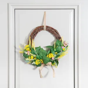 Artificial floral wreath detail shot featuring green leaves and yellow wildflowers for home decor.