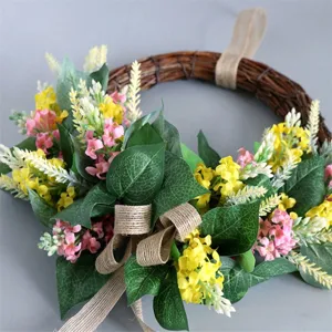 Detail view of artificial floral wreath, rustic farmhouse door hanging with green leaves and bow.