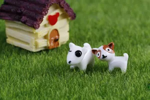 Miniature cartoon dog figurines ornament detail on grass background, perfect for micro landscaping.
