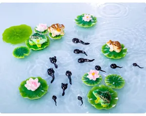 Gedetailleerd overzicht van miniatuur hars kikkers en kikkervisjes ornamenten op wateroppervlak.