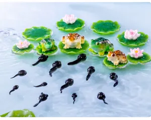 Gedetailleerd overzicht van miniatuur hars kikker en kikkervisje ornamenten met leliebladeren.