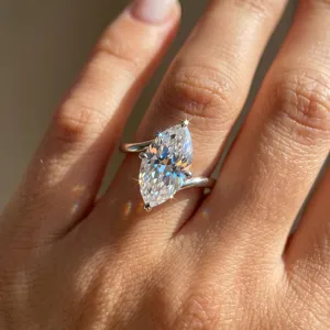 Primo piano di un anello scintillante con taglio marquise e fascia d'argento ritorta
