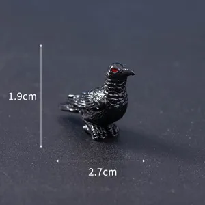 Miniature black crow figurine for Halloween micro landscape decoration with red eyes, detail view.