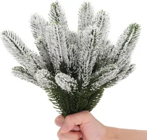 Gedetailleerd aanzicht van kunstmatige bevlokte dennentakken voor kerstdecoratie en knutselen.