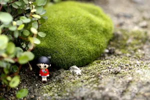 Closeup detail of simulated moss stone with miniature figure, perfect for micro landscape decor.
