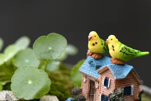 Close-up detail of cute resin parrot figurines on mini house, perfect for DIY micro landscape.