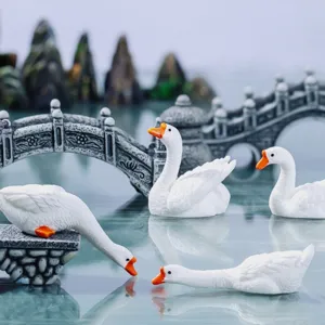 Miniature resin white goose figurines with stone bridge rockery for bonsai tea table decor.