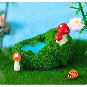 Miniature moss pond garden decoration detail with mushrooms and ladybug ornament.